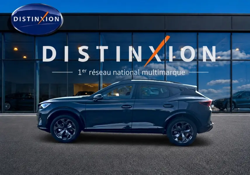 Vue de profil côté gauche d'un CUPRA Formentor 1.5 etsi hybrid bleu fjord garé devant une vitrine Distinxion.