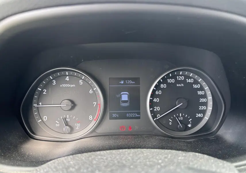 Tableau de bord de Hyundai i30 blanc 2018, affichant compte-tours, vitesse, température et écran central digital.