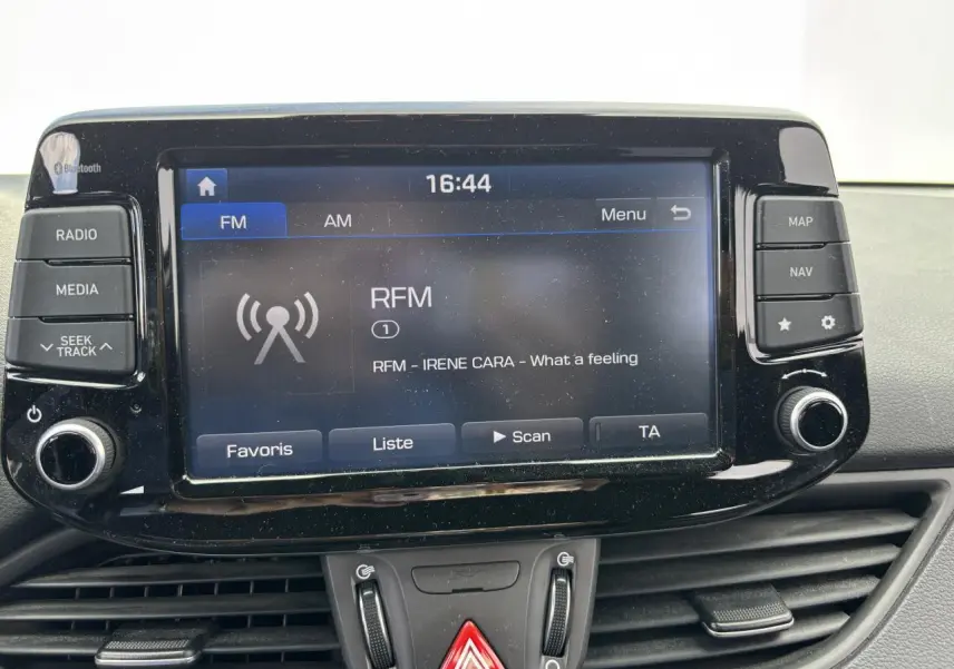 Écran tactile multimédia de la Hyundai i30 III SW blanc, affichant la radio FM avec commandes autour.