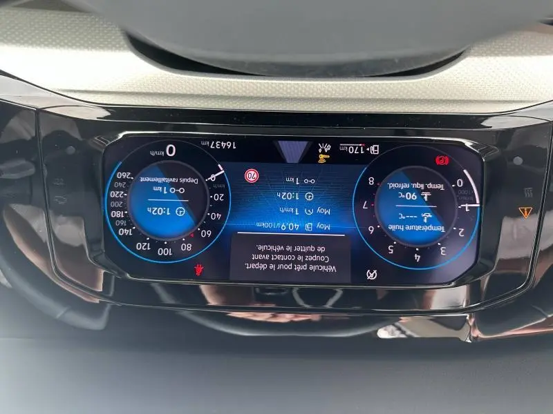 Vue rapprochée du tableau de bord numérique de la Volkswagen Golf 2024, affichage couleur avec compteurs ronds bleus.