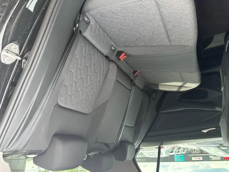 Vue intérieure de la banquette arrière grise et noire de la Volkswagen Golf 2024, avec ceintures de sécurité visibles.
