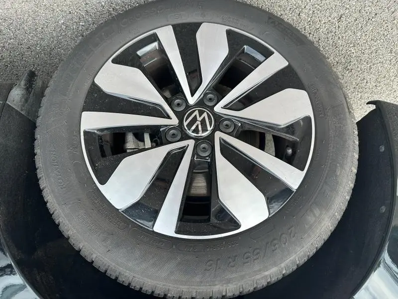 Gros plan sur la jante alu bicolore noire et argentée d'une Volkswagen Golf 1.5 eTSI 2024, roue de secours visible.