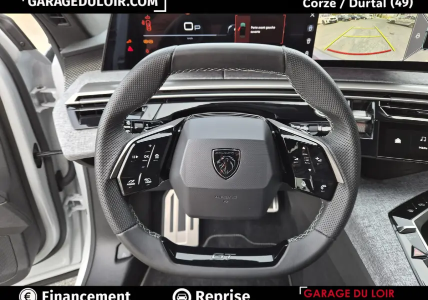 Vue intérieure centrée sur le volant cuir noir GT du Peugeot 3008 blanc, avec tableau de bord numérique et écran de caméra de recul.