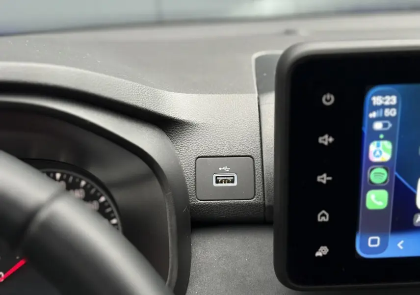 Gros plan intérieur sur la prise USB et l'écran tactile du tableau de bord de la Dacia Sandero Stepway Bleu Iron.