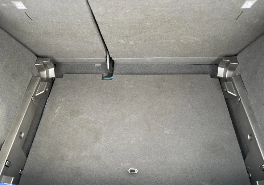 Vue plongeante sur le coffre spacieux de la Dacia Sandero Stepway Bleu Iron, avec banquette arrière rabattue.