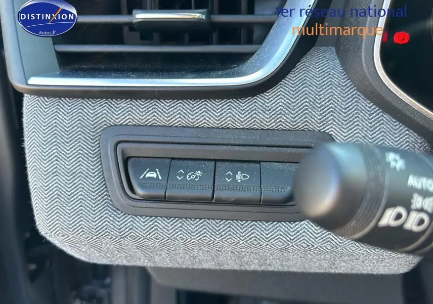 Détail des commandes d'assistance sur tableau de bord avec habillage textile gris à chevrons Renault Clio V 2024