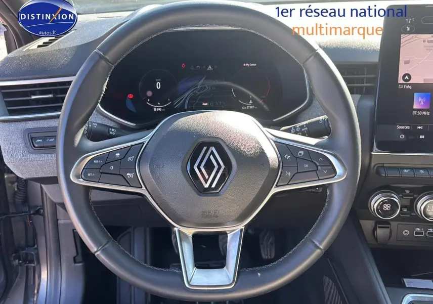 Volant cuir gris avec logo Renault au centre, tableau de bord numérique et écran tactile du système multimédia d'une Clio V gris pizarra 2024.