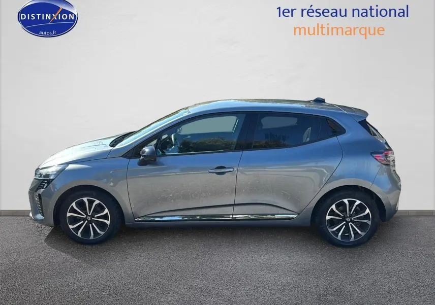 Profil droit de la Renault Clio V gris pizarra 2024 avec jantes alliage noires et détails chromés sur les portes.