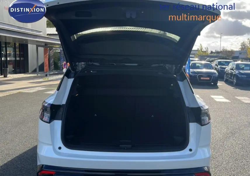 Vue arrière d'un Renault Austral Iconic Esprit Alpine blanc et noir avec coffre ouvert sur un parking.