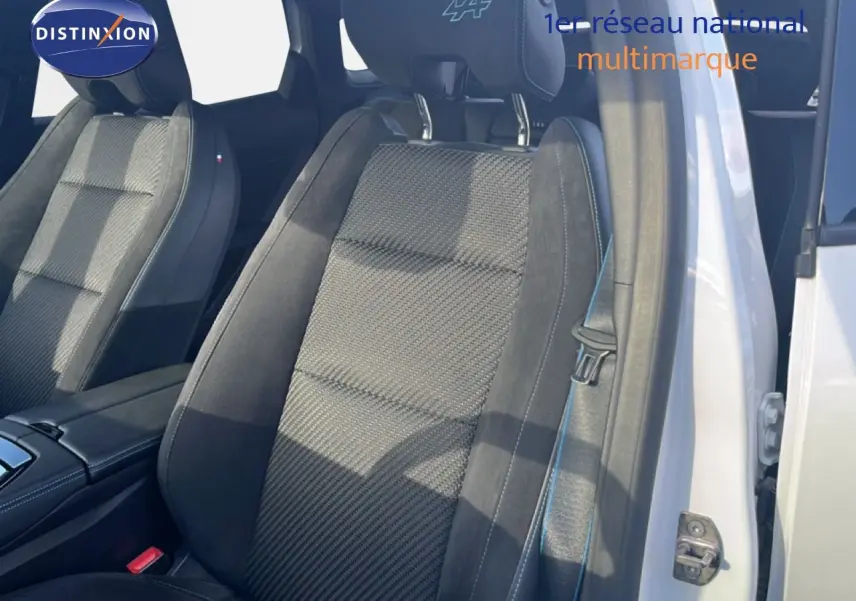 Gros plan sur le siège avant droit noir et gris avec surpiqûres bleues et logo Alpine sur l'appuie-tête du Renault Austral Iconic Esprit Alpine.