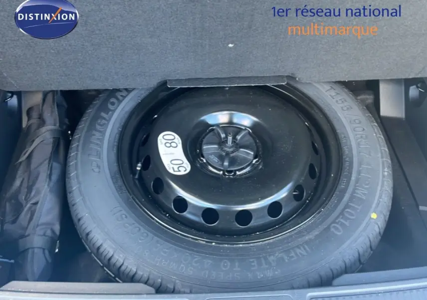 Roue de secours noire en gros plan dans le coffre d'un Renault Austral Iconic Esprit Alpine blanc/noir 2024.
