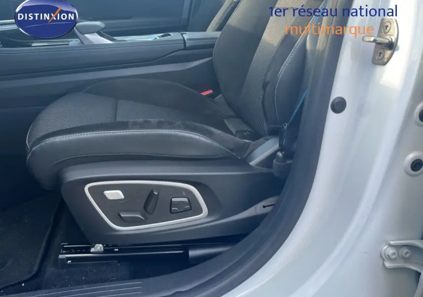 Gros plan sur le siège conducteur noir avec réglages électriques, porte ouverte d'une Renault Austral Iconic Esprit Alpine blanc/noir 2024.