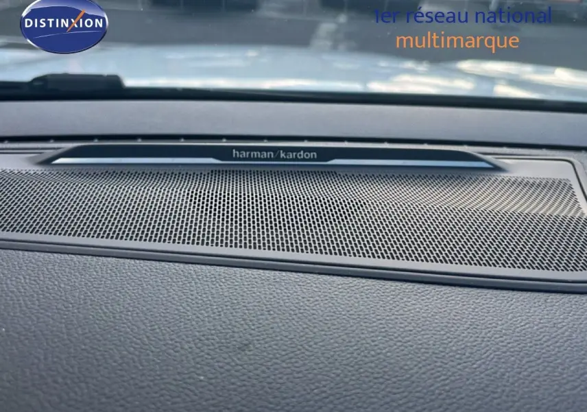 Gros plan sur la grille de haut-parleur Harman Kardon intégrée au tableau de bord du Renault Austral Iconic Esprit Alpine blanc et noir.