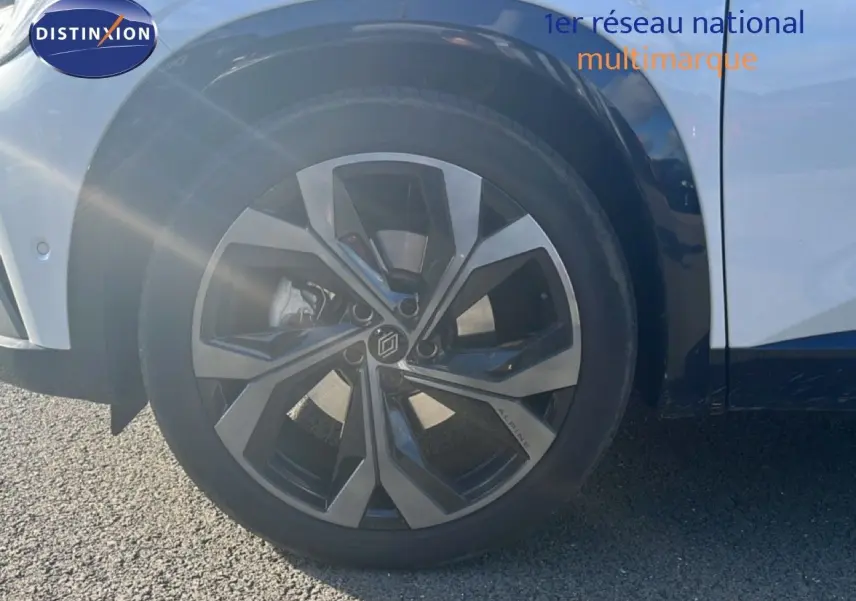 Gros plan sur la roue avant gauche du Renault Austral Iconic Esprit Alpine blanc et noir, jante alu distinctive.