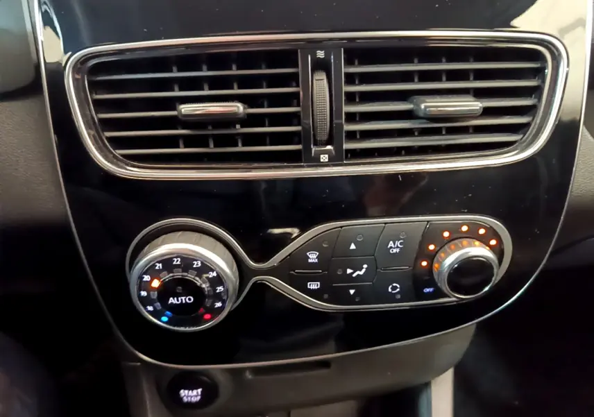 Gros plan sur la console centrale noire de la Renault Clio Business, montrant les commandes de climatisation et la ventilation.