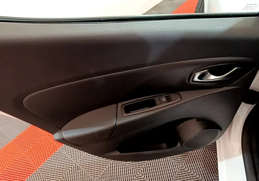 Vue rapprochée de la porte côté conducteur d'une Renault Clio Business blanche, avec poignée et commande de vitre noire.