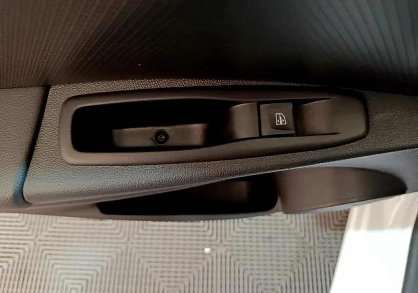 Gros plan sur la commande de lève-vitre côté conducteur de la Renault Clio Business TCe 90 blanche de 2019.