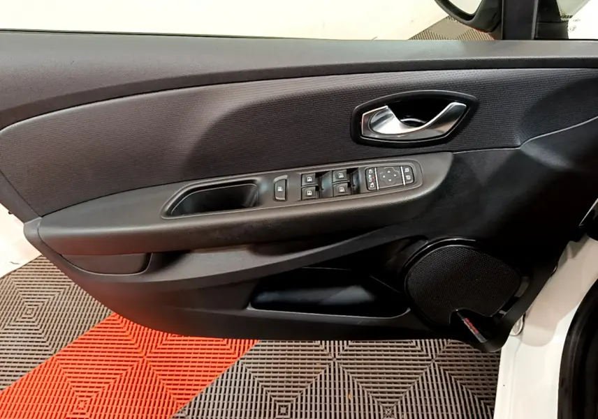 Vue intérieure du panneau de porte côté conducteur d'une Renault Clio Business TCe 90 blanche avec commandes électriques et haut-parleur intégré.