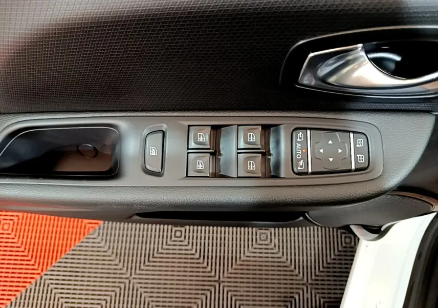 Vue rapprochée de la porte avant gauche blanche d'une Renault Clio Business avec commandes électriques des vitres et rétroviseurs.