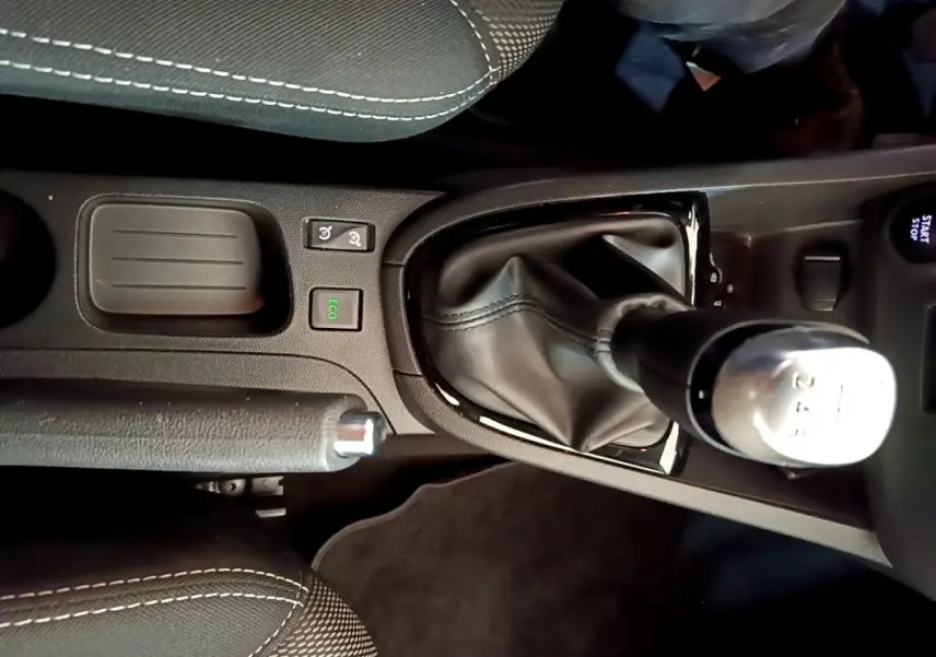 Vue rapprochée de la console centrale noire de la Renault Clio Business TCe 90 avec levier de vitesse manuel et bouton Start/Stop.