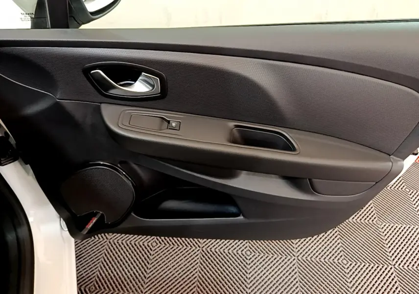 Gros plan sur la porte avant gauche noire de la Renault Clio Business TCe 90 blanche, avec poignée et haut-parleur intégrés.