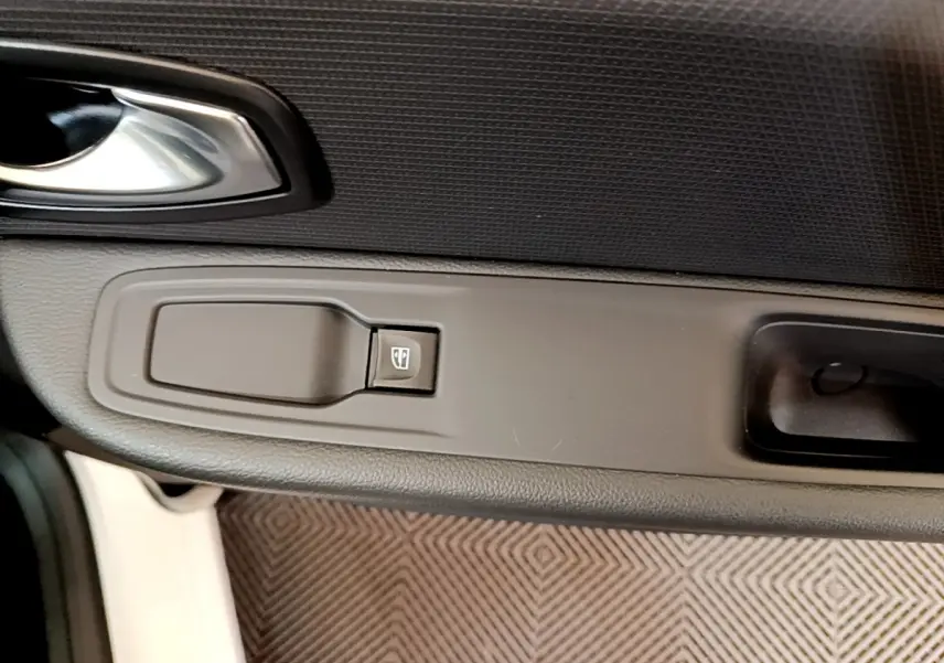 Gros plan sur la commande de lève-vitre côté conducteur de la Renault Clio Business TCe 90 blanche de 2019.