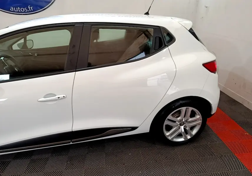 Profil côté gauche d'une Renault Clio Business TCe 90 blanche avec jantes alliage et poignées de porte intégrées.