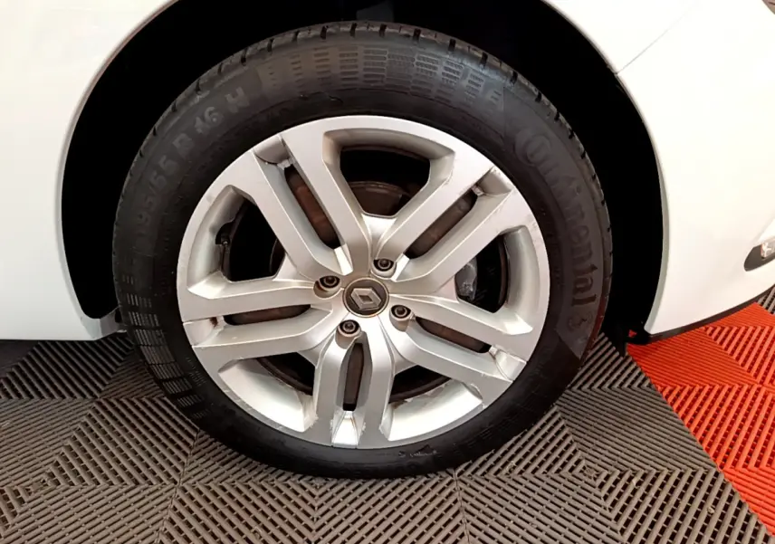 Gros plan sur la roue avant droite d'une Renault Clio Business TCe 90 blanche avec jante alliage et pneu Continental.