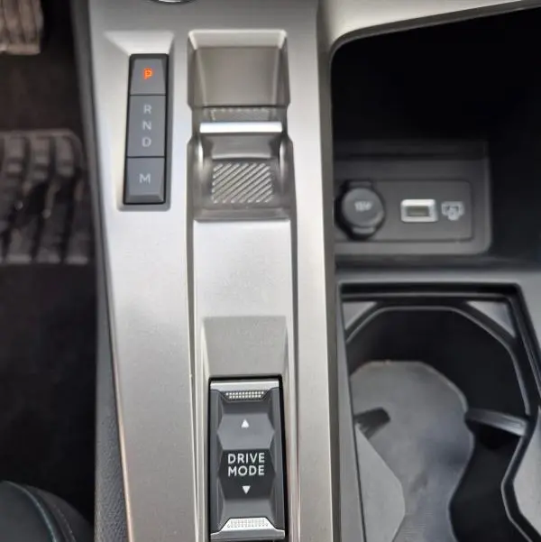 Vue rapprochée de la console centrale de la Peugeot 308 2024, avec levier de vitesses automatique et bouton Drive Mode.