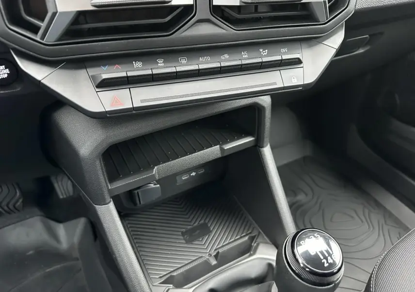 Gros plan sur la console centrale noire du Dacia Duster 2025 avec boîte manuelle et prises USB type C visibles.