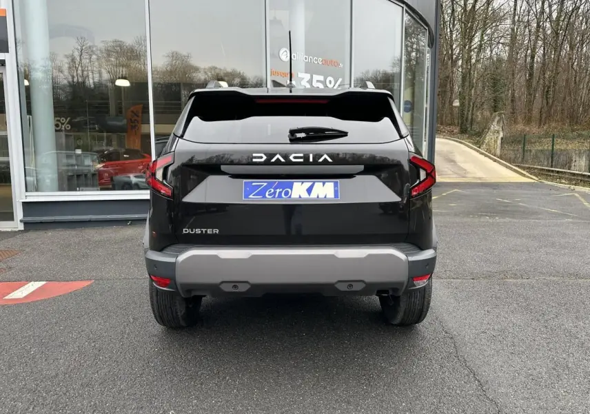 Vue arrière d'un Dacia Duster noir 2025 avec barres de toit et feux arrière en forme de C.
