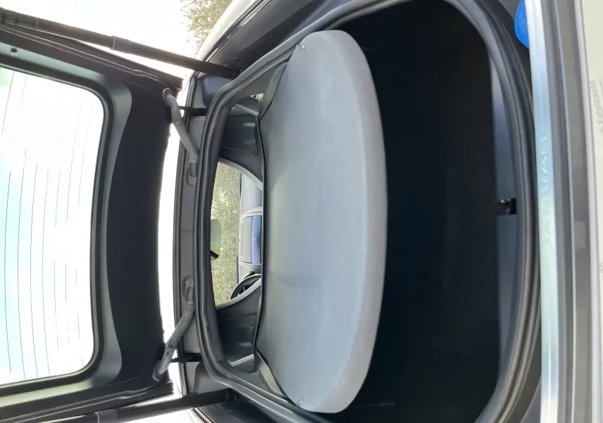 Coffre ouvert vu de l'arrière d'une Jaguar F-TYPE II Coupé 2.0T 300 BVA8 gris Corris, montrant l'espace de rangement.