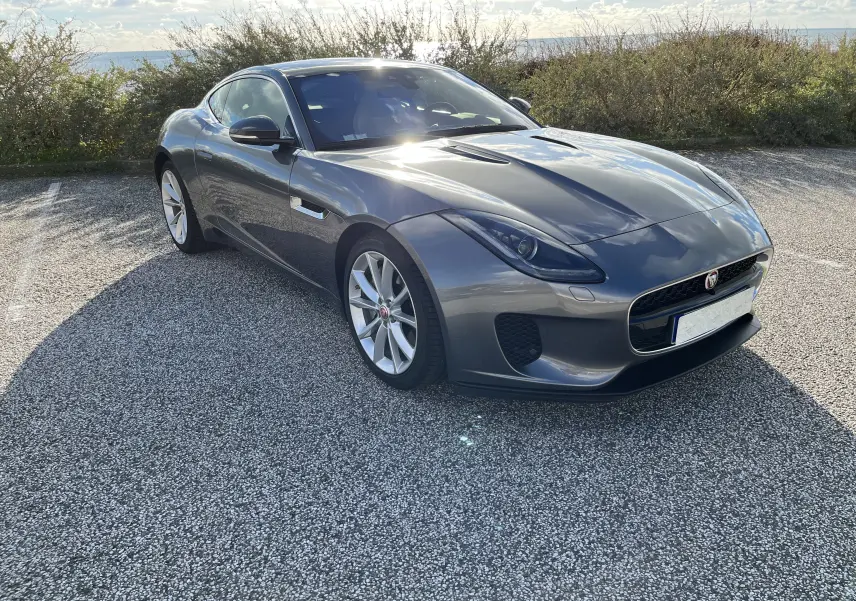 Jaguar F-TYPE II Coupé 2.0T gris Corris en 3/4 avant droit, avec jantes 19 pouces et calandre distinctive.
