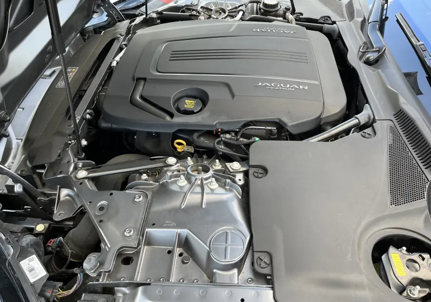Vue rapprochée du moteur Jaguar Ingenium sous le capot d'une F-TYPE II Coupé 2.0T 300 BVA8 gris Corris.