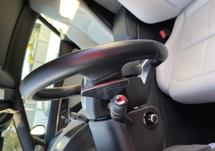Vue rapprochée du volant sport noir et du siège cuir gris clair de la Jaguar F-TYPE II Coupe 2018, intérieur premium.