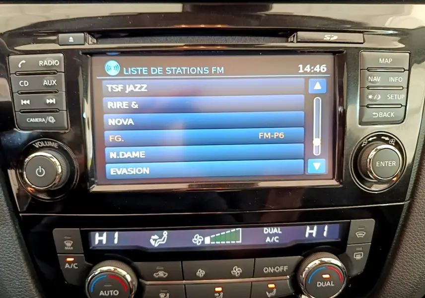 Vue rapprochée de l’écran tactile central et des commandes de climatisation du Nissan Qashqai blanc 2019.