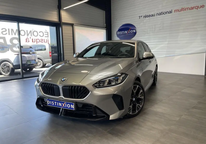 BMW Série 1 120d M Sport gris vue 3/4 avant en intérieur, avec calandre noire et jantes sport noires.