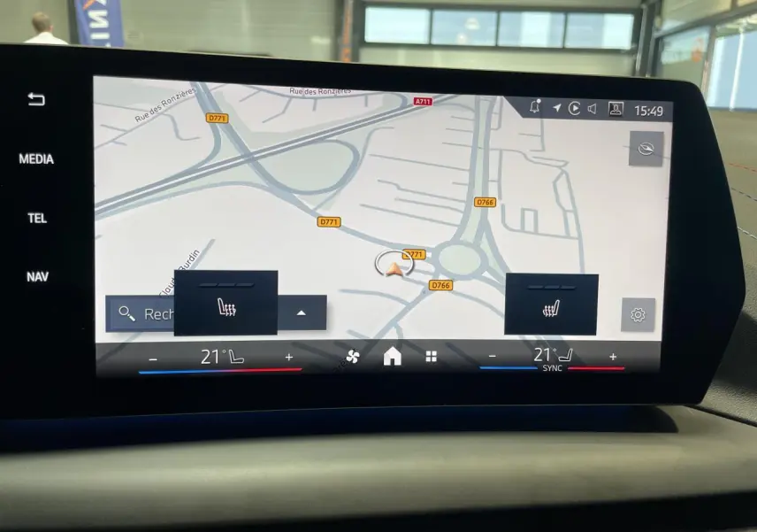Écran central de navigation et climatisation affichant une carte, dans une BMW Série 1 120d M Sport gris 2025.