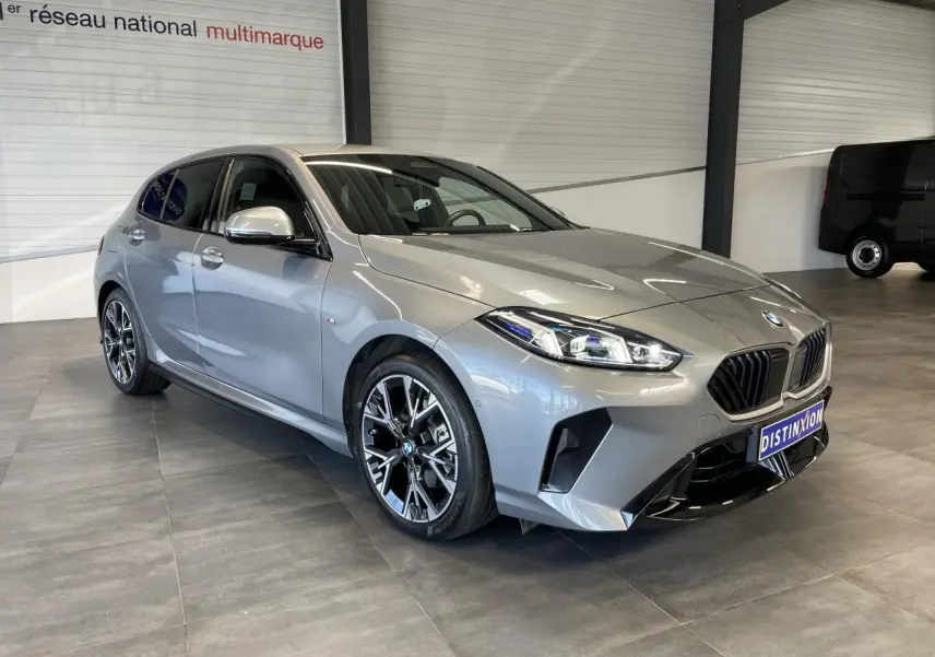BMW Série 1 120d M Sport gris vue 3/4 avant droit, avec calandre noire et jantes alliage distinctives.