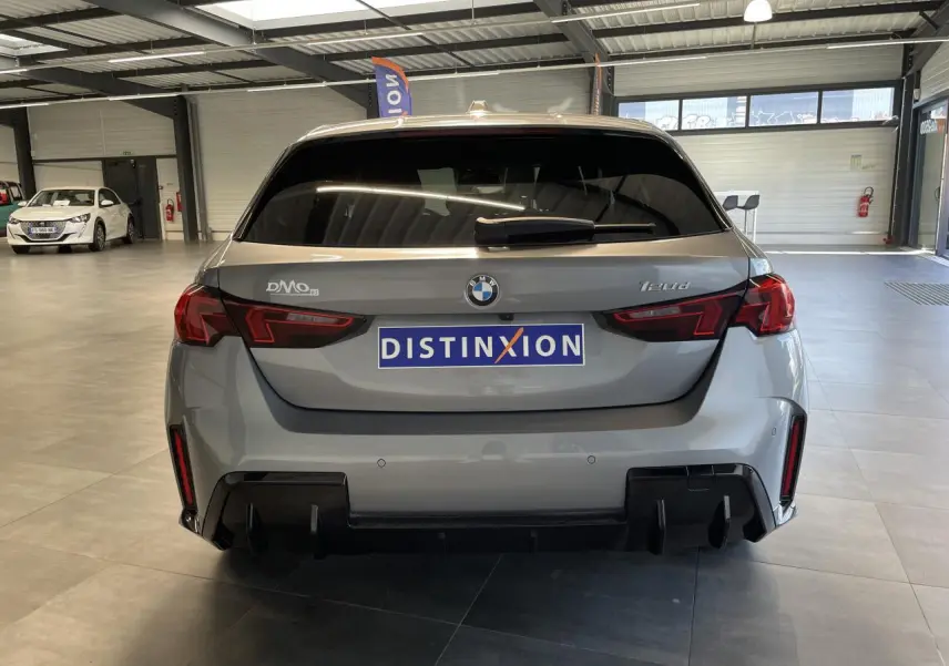 Vue arrière d'une BMW Série 1 120d gris 2025 en finition M Sport avec diffuseur noir et feux LED distinctifs.