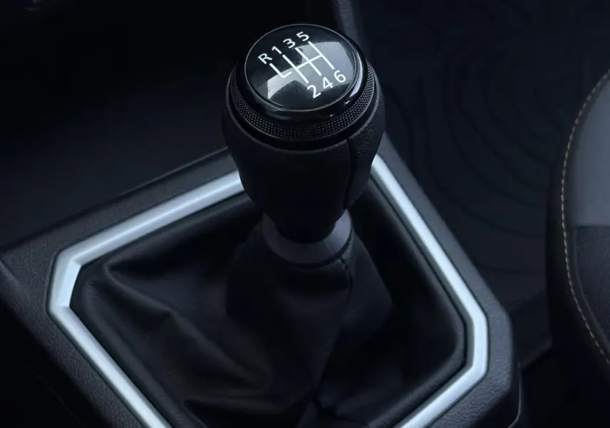 Gros plan sur le levier de vitesses manuel noir de la Dacia Sandero Stepway 2025, intérieur avec coutures contrastées.