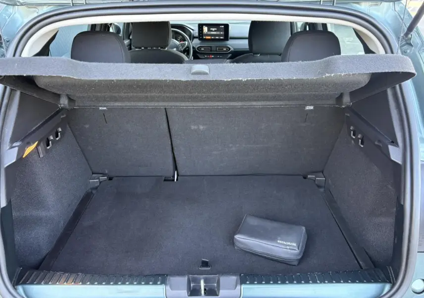 Coffre ouvert vu de l'arrière d'une Dacia Sandero Stepway Vert Cèdre, banquette arrière et tableau de bord visibles.