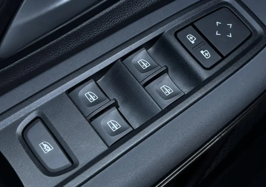 Gros plan sur les commandes de lève-vitres et réglages des rétroviseurs côté conducteur de la Dacia Sandero Stepway Vert Cèdre.