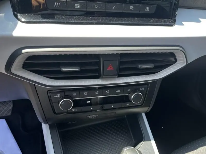 Détail de la console centrale du SEAT Arona blanc 2024, avec commandes climatisation et aérateurs horizontaux.