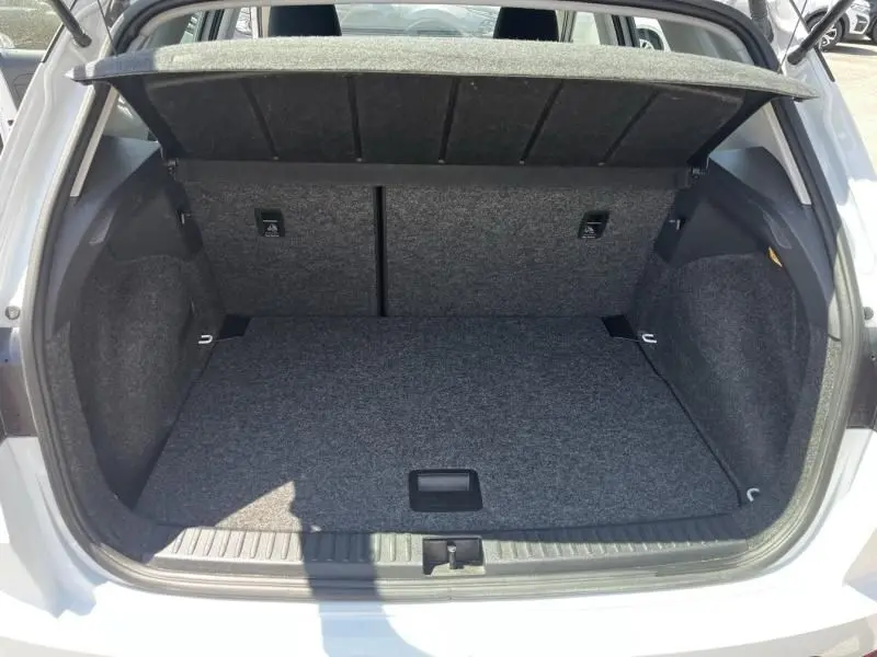 Coffre ouvert vu de l'arrière d'un SEAT Arona blanc 2024, montrant l'espace de chargement et la tablette cache-bagages.