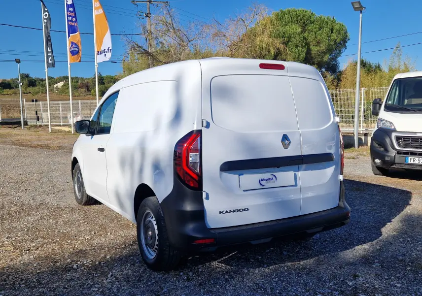 Renault Kangoo blanc vue 3/4 arrière droit, fourgon utilitaire avec porte arrière pleine et feux rouges distinctifs.