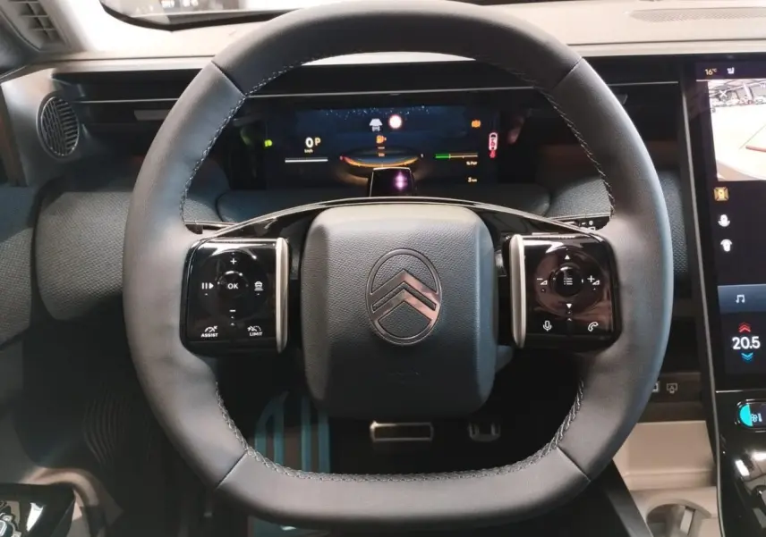 Vue rapprochée du volant multifonctions noir brillant du Citroën C5 Aircross 2026 avec tableau de bord numérique.