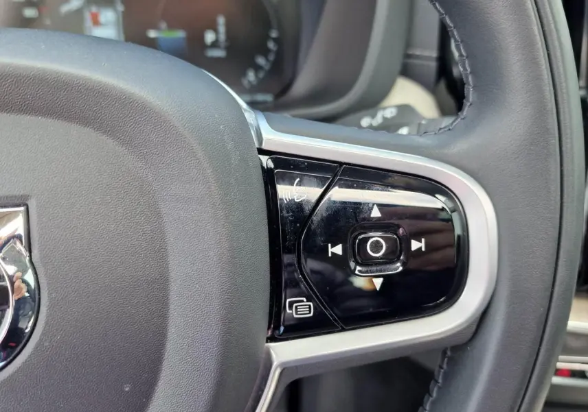 Gros plan sur les commandes multifonctions à droite du volant noir du Volvo XC60 II Recharge T6 340 Inscription Luxe.