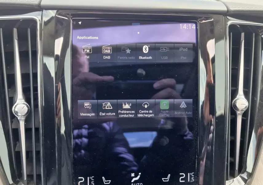 Écran tactile central du tableau de bord du Volvo XC60 noir, affichant les options multimédia et climatisation.