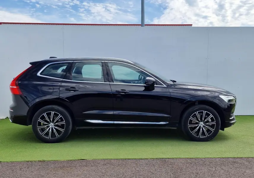 Profil côté gauche d'un Volvo XC60 noir 2021 avec jantes alliage 19 pouces et toit panoramique.